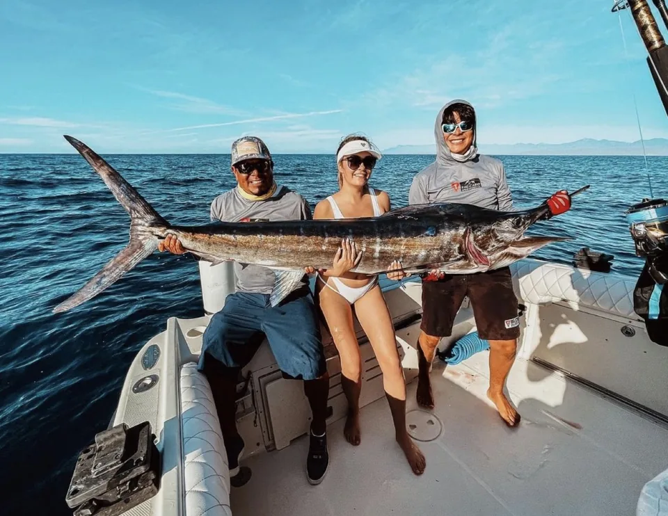 Crew and guest with a striped marlin before release off Cabo San Lucas